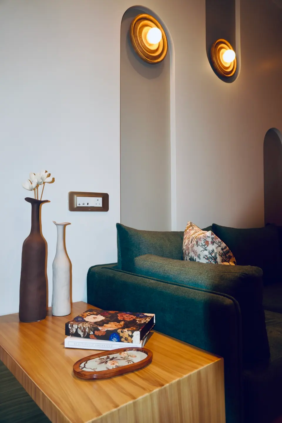 Two bottle vases on a wooden side table
